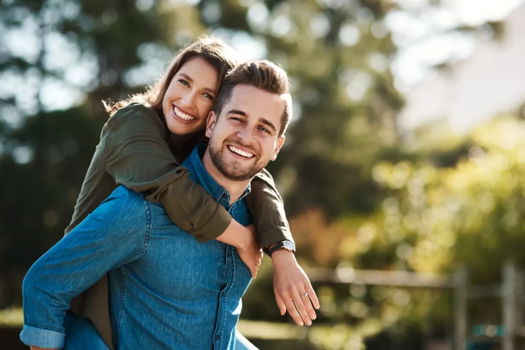 happy couple enjoying piggyback ride in the sun utc